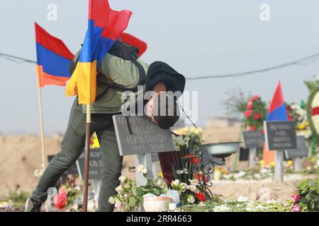 201121 -- EREVAN, 21 novembre 2020 -- Un uomo bacia la lapide di un soldato caduto ucciso nel conflitto del Nagorno-Karabakh a Erevan, Armenia, 20 novembre 2020. Il presidente azero Ilham Aliyev, il primo ministro armeno Nikol Pashinyan e il presidente russo Vladimir Putin hanno rilasciato una dichiarazione congiunta il 10 novembre, concordando su un cessate il fuoco completo nel Nagorno-Karabakh. Un elemento chiave della dichiarazione congiunta è stato lo schieramento di un contingente di peacekeeping russo lungo la linea di contatto nel Nagorno-Karabakh e nel corridoio di Lachin. Azerbaigian e Armenia si scambieranno anche prigionieri di guerra, altri detenuti Foto Stock