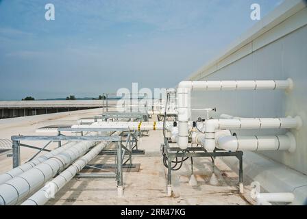 Tubazioni isolate bianche montate sul tetto di un impianto di stoccaggio a freddo, per il trasporto di liquidi e gas nella refrigerazione a ciclo di ammoniaca. Foto Stock