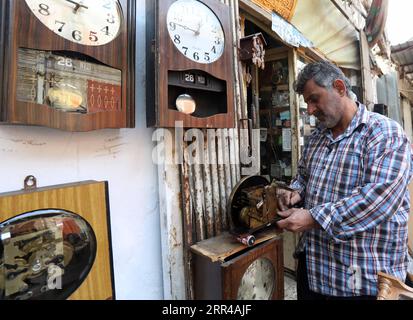 201127 -- BAGHDAD, 27 novembre 2020 -- Guarda il riparatore Ali Mahmoud lavora nel suo negozio nel mercato Haraj a Baghdad, Iraq, 25 novembre 2020. Nel vecchio e popolare mercato di Haraj nel centro di Baghdad, i riparatori di orologi stanno lottando per preservare questa professione tradizionale colpita dalla scarsità di pezzi di ricambio per vecchi orologi e dai prezzi economici dei nuovi prodotti importati. IRAQ-BAGHDAD-OROLOGIO REPAIRMEN Xinhua PUBLICATIONxNOTxINxCHN Foto Stock