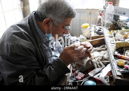 201127 -- BAGHDAD, 27 novembre 2020 -- Un tecnico di sorveglianza senior ripara un orologio da polso nel mercato Haraj a Baghdad, Iraq, 25 novembre 2020. Nel vecchio e popolare mercato di Haraj nel centro di Baghdad, i riparatori di orologi stanno lottando per preservare questa professione tradizionale colpita dalla scarsità di pezzi di ricambio per vecchi orologi e dai prezzi economici dei nuovi prodotti importati. IRAQ-BAGHDAD-OROLOGIO REPAIRMEN Xinhua PUBLICATIONxNOTxINxCHN Foto Stock