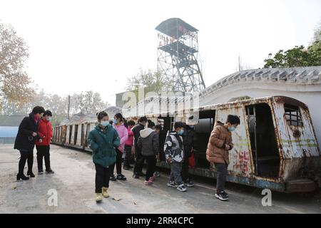 201129 -- JIAOZUO, 29 novembre 2020 -- i turisti guardano un tram alla miniera di Wangfeng nella città di Jiaozuo, provincia di Henan, Cina centrale, 29 novembre 2020. La miniera di Wangfeng, situata nel distretto di Zhongzhan della città di Jiaozuo, è stata sfruttata nel 1919 e ha una storia di oltre 100 anni. Negli ultimi anni, le autorità locali hanno trasformato la miniera secolare in un parco turistico e culturale con elementi industriali per sfruttare appieno le reliquie industriali. Foto di /Xinhua CHINA-HENAN-JIAOZUO-MINE TRANSFORMED TOURISM PARK CN FengxXiaomin PUBLICATIONxNOTxINxCHN Foto Stock