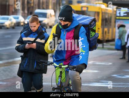 201203 -- MINSK, 3 dicembre 2020 -- Un corriere che indossa una maschera per il viso cavalca una bicicletta per strada a Minsk, Bielorussia, 3 dicembre 2020. La Bielorussia ha segnalato 1.701 nuovi casi di COVID-19 giovedì, portando il suo totale a 141.609, il ministero della salute del paese ha riferito. Finora, 1.181 persone sono morte per la malattia nel paese, di cui sette nelle ultime 24 ore, ha detto. Ci sono stati 1.729 nuovi recuperi nelle ultime 24 ore, portando il totale a 118.924, ha aggiunto il ministero. Foto di /Xinhua BELARUS-MINSK-COVID-19 CASI HenadzxZhinkov PUBLICATIONxNOTxINxCHN Foto Stock
