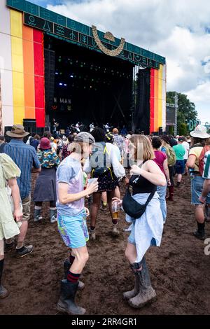 Una giovane coppia che danza con le birre nel fango al Mountain Stage al Green Man Festival, Brecon, Galles, Regno Unito, 2023. Foto: Rob Watkins Foto Stock