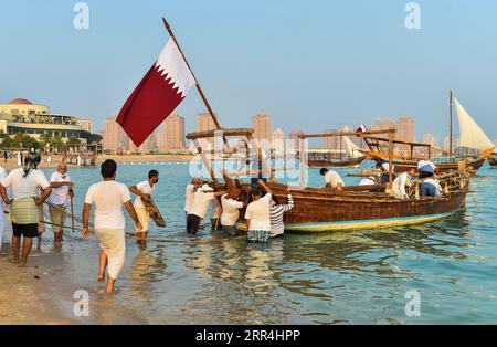 201205 -- DOHA, 5 dicembre 2020 -- la gente si prepara a lanciare un dhow in mare durante il 10 ° Katara Traditional Dhow Festival a Doha, capitale del Qatar, 5 dicembre 2020. Il festival si è tenuto dal 1 al 5 dicembre qui per mettere in mostra le tradizioni marittime. Foto di /Xinhua QATAR-DOHA-TRADITIONAL DHOW FESTIVAL Nikku PUBLICATIONxNOTxINxCHN Foto Stock