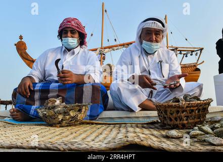 201205 -- DOHA, 5 dicembre 2020 -- gli uomini del Qatar aprono ostriche ed estraggono perle durante il 10° Katara Traditional Dhow Festival a Doha, capitale del Qatar, 5 dicembre 2020. Il festival si è tenuto dal 1 al 5 dicembre qui per mettere in mostra le tradizioni marittime. Foto di /Xinhua QATAR-DOHA-TRADITIONAL DHOW FESTIVAL Nikku PUBLICATIONxNOTxINxCHN Foto Stock