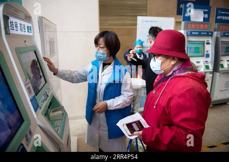 201210 -- PECHINO, 10 dicembre 2020 -- Un membro dello staff aiuta un cittadino anziano a controllare le informazioni sugli appuntamenti su una macchina presso l'ospedale Tiantan di Pechino sotto la Capital Medical University di Pechino, capitale della Cina, 9 dicembre 2020. La Cina ha lanciato una campagna triennale per aiutare gli anziani del paese a superare il divario digitale e a godere dello sviluppo di tecnologie intelligenti. Il governo ha recentemente pubblicato un piano che specifica le misure per aiutare gli anziani a superare le barriere all'uso delle tecnologie intelligenti mantenendo al contempo i servizi tradizionali per loro. Il piano, emesso dall'Ufficio generale o Foto Stock
