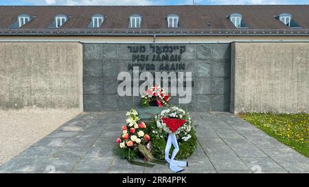 Mai più in cinque lingue sul memoriale dei prigionieri sconosciuti presso l'ex campo di concentramento nazista di Dachau, Monaco, Germania Foto Stock