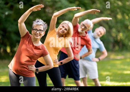Esercizi di fitness per anziani. Allenamento sportivo con persone mature all'aperto Foto Stock