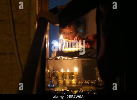 201214 -- PECHINO, 14 dicembre 2020 -- un ragazzo ebreo ultra-ortodosso accende una candela durante il festival di Hanukkah a Gerusalemme il 12 dicembre 2020. Foto di /Xinhua XINHUA FOTO DEL GIORNO MuammarxAwad PUBLICATIONxNOTxINxCHN Foto Stock