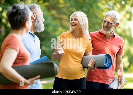 Gruppo di persone anziane felici che parlano tra loro dopo l'allenamento all'aperto Foto Stock