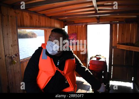 201218 -- JINZHAI, 18 dicembre 2020 -- Yu Jiajun guida la sua barca per fare una visita nella contea di Jinzhai della città di Luan, nella provincia di Anhui della Cina orientale, 16 dicembre 2020. Nel profondo dell'area del bacino idrico di Xianghongdian nella contea di Jinzhai della città di Luan, nella provincia di Anhui della Cina orientale, c'è un'isola isolata, che un tempo ospitava oltre 40 famiglie povere. Yu Jiajun, 42 anni, è l'unico medico del villaggio. In passato, non c'era nessuna stazione sanitaria sull'isola. Gli abitanti del villaggio hanno dovuto remare una barca per due o tre ore per andare al centro sanitario di Mabu Township per vedere il medico. Yu Said. Quando Yu Jiajun tornò al villaggio Foto Stock