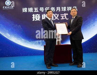 201219 -- PECHINO, 19 dicembre 2020 -- Hou Jianguo R, presidente della Chinese Academy of Sciences CAS, rilascia una lettera di responsabilità a Chang Jin, direttore degli osservatori astronomici nazionali sotto il CAS, a Pechino, capitale della Cina, 19 dicembre 2020. Sabato si è tenuta una cerimonia presso gli osservatori astronomici nazionali sotto il CAS per ricevere i campioni lunari recuperati dalla sonda cinese Chang e-5. EyesonSciCHINA-BEIJING-CHANG e-5-LUNAR SAMPLES CN JinxLiwang PUBLICATIONxNOTxINxCHN Foto Stock