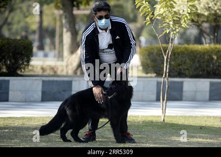 201220 -- RAWALPINDI, 20 dicembre 2020 -- Un uomo si prende cura del suo cane durante l'All Breed Dog Show a Rawalpindi, nella provincia pakistana del Punjab, il 20 dicembre 2020. L'All Breed Dog Show si è tenuto domenica e ha attirato molti concorrenti per mostrare i loro cani. PAKISTAN-RAWALPINDI-DOG SHOW AhmadxKamal PUBLICATIONxNOTxINxCHN Foto Stock