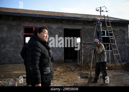 201225 -- YINCHUAN, 25 dicembre 2020 -- Ding Haiyan segue la costruzione di una mensa quasi pronta per gli anziani, l'ultima delle sue promesse agli abitanti del villaggio, nel villaggio di Hejiayuan di Xihaigu, nella regione autonoma Ningxia Hui della Cina nord-occidentale, 28 ottobre 2020. Xihaigu, una regione in gran parte montuosa nel nord-ovest di Ningxia, una volta fu inflitta dalla povertà profonda ed etichettata come il luogo più inadatto per l'insediamento umano da parte delle Nazioni Unite negli anni '1970 a causa della bonifica delle terre, della siccità e di un fragile ambiente ecologico. Il 16 novembre 2020, Xihaigu storicamente porge l'addio alla povertà assoluta, Foto Stock