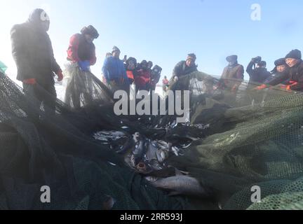 201227 -- FUHAI, 27 dicembre 2020 -- i pescatori trascinano le reti durante la pesca invernale sul lago congelato Ulunggur nella contea di Fuhai, regione autonoma Xinjiang Uygur della Cina nordoccidentale, 27 dicembre 2020. Ogni anno, i pescatori seguono il tradizionale metodo di pesca invernale mettendo sotto il ghiaccio una rete gigante per pescare sul lago Frozon Ulunggur, uno dei dieci laghi d'acqua dolce più grandi della Cina. CHINA-XINJIANG-FUHAI-ULUNGGUR LAGO-PESCA INVERNALE CN SADAT PUBLICATIONXNOTXINXCHN Foto Stock