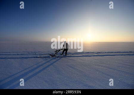 201227 -- FUHAI, 27 dicembre 2020 -- Un pescatore lavora sulla pesca invernale sul lago congelato Ulunggur nella contea di Fuhai, regione autonoma Xinjiang Uygur della Cina nordoccidentale, 27 dicembre 2020. Ogni anno, i pescatori seguono il tradizionale metodo di pesca invernale mettendo sotto il ghiaccio una rete gigante per pescare sul lago Frozon Ulunggur, uno dei dieci laghi d'acqua dolce più grandi della Cina. CHINA-XINJIANG-FUHAI-ULUNGGUR LAGO-PESCA INVERNALE CN SADAT PUBLICATIONXNOTXINXCHN Foto Stock