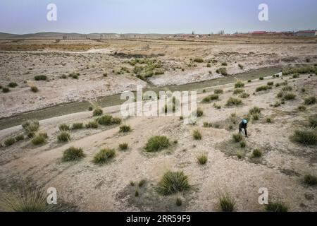 201228 -- YINCHUAN, 28 dicembre 2020 -- foto aerea scattata il 27 ottobre 2020 mostra li Yaomei che taglia cannucce per la produzione di scopa nel villaggio Longyuan del distretto di Hongsibao nella città di Wuzhong, nella regione autonoma Ningxia Hui della Cina nord-occidentale. Xihaigu, una regione in gran parte montuosa nel Ningxia centro-meridionale, una volta fu inflitta dalla povertà profonda ed etichettata come il luogo più inadatto per l'insediamento umano da parte delle Nazioni Unite negli anni '1970 a causa della bonifica del terreno, della siccità e di un fragile ambiente ecologico. Il 16 novembre 2020, Xihaigu storicamente salutò la povertà assoluta, durante la quale il suo potere giocò un ruolo Foto Stock