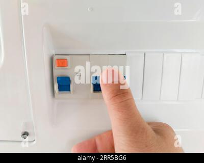 Premere con un dito la leva dell'interruttore automatico a corrente residua. Messa a fuoco selettiva Foto Stock