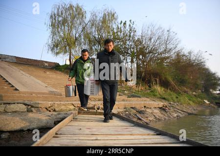 210101 -- CHANGSHA, 1 gennaio 2021 -- Shi Zhongfang aiuta le sue relative necessità quotidiane di traghetti dall'isola Lianhua ao del villaggio di Lianhuadao nella città di Yuanjiang, nella provincia di Hunan della Cina centrale, 21 dicembre 2020. Shi Zhongfang, un ex pescatore dell'Isola di Lianhua ao, situata nel mezzo del Lago Dongting, gestisce ora un ristorante che propone la tradizionale cucina di pesce dei pescatori nella città di Yuanjiang. Era il pescatore della settima generazione della sua famiglia e ha iniziato a pescare all'età di 14 anni. La sua vita è cambiata in seguito a un divieto di pesca. Secondo il piano del governo centrale, un completo 1 Foto Stock