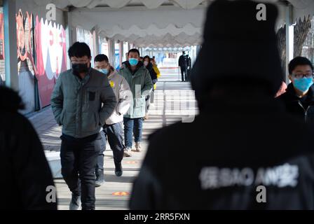 210106 -- PECHINO, 6 gennaio 2021 -- Mr. Wu 3rd L, front attende in fila per ricevere un vaccino anti COVID-19 in un sito di inoculazione nel distretto di Chaoyang, Pechino, capitale della Cina, 5 gennaio 2021. Insieme a più di 70 dei suoi colleghi del settore della trasformazione alimentare, il signor Wu, il cui nome è stato omesso per la tutela della privacy, 40 anni, è salito su un bus navetta che li avrebbe portati in un luogo di vaccinazione intorno alle 13 di martedì. Wu, che lavora per un'azienda che si occupa di pasticceria, panificazione e trasporto della catena del freddo, ha detto che tutti i suoi colleghi, tranne quelli con condizioni fisiche inadeguate, si erano registrati Foto Stock