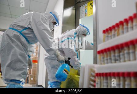 210108 -- SHIJIAZHUANG, 8 gennaio 2021 -- Mei Yiqi R mette scatole contenenti campioni di acido nucleico nel laboratorio di un istituto di analisi a Shijiazhuang, nella provincia di Hebei, nel nord della Cina, 8 gennaio 2021. Mei Yiqi, 30 anni, che lavora nel dipartimento logistico di Wuhan KingMed Diagnostics Group Co., Ltd., ha salutato la sua famiglia mercoledì e ha preso un treno ad alta velocità da Wuhan a Shijiazhuang per aiutare a combattere la pandemia di COVID-19. Nel 2020 Mei ha partecipato al lavoro anti-pandemia a Wuhan e Chengdu, assumendo successivamente la responsabilità della raccolta e del trasporto dei test per la COVID-19 Foto Stock