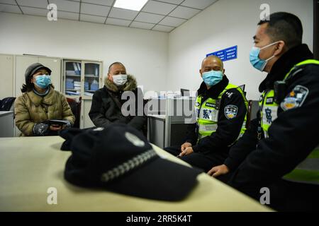 210109 -- CHENGDU, 9 gennaio 2021 -- Qiao Zhibing2nd R e Yang Duo1st R comunicano con le persone responsabili della sicurezza e della protezione nella società di servizi immobiliari Kaidi a Chengdu, nella provincia del Sichuan della Cina sud-occidentale, 8 gennaio 2021. Il 10 gennaio 2021 segna la prima giornata cinese della polizia del popolo cinese, ma per Qiao Zhibing, un poliziotto di 59 anni della stazione di polizia di Jiangxi Street del distretto di Wuhou dell'ufficio di pubblica sicurezza di Chengdu, sarà il suo ultimo giorno di polizia in quanto andrà in pensione all'età di 60 anni nel giugno di quest'anno. Mentre si avvicina la giornata della polizia del popolo cinese, i colleghi di t Foto Stock