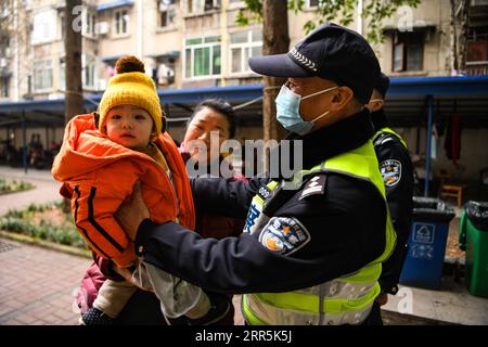 210109 -- CHENGDU, 9 gennaio 2021 -- Qiao ZhibingR tiene un bambino in un'area residenziale a Chengdu, nella provincia del Sichuan della Cina sud-occidentale, 8 gennaio 2021. Il 10 gennaio 2021 segna la prima giornata cinese della polizia del popolo cinese, ma per Qiao Zhibing, un poliziotto di 59 anni della stazione di polizia di Jiangxi Street del distretto di Wuhou dell'ufficio di pubblica sicurezza di Chengdu, sarà il suo ultimo giorno di polizia in quanto andrà in pensione all'età di 60 anni nel giugno di quest'anno. Mentre si avvicina la giornata della polizia popolare cinese, i colleghi della stazione di polizia hanno tenuto un piccolo forum di addio per ringraziarlo per il duro lavoro svolto per i cittadini Foto Stock