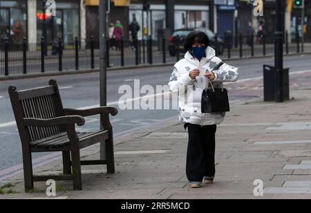 210110 -- LONDRA, 10 gennaio 2021 -- Una donna che indossa una maschera cammina in una strada a Londra, in Gran Bretagna, 10 gennaio 2021. I decessi correlati al coronavirus in Gran Bretagna hanno superato i 80.000 di sabato, mentre altri 1.035 sono stati segnalati nel paese. REGNO UNITO-LONDRA-COVID-19-CASI HanxYan PUBLICATIONxNOTxINxCHN Foto Stock