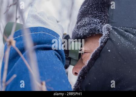 210113 -- MOHE, 13 gennaio 2021 -- LYU Jiansheng conduce pattugliamento di linee elettriche nella foresta vicino al villaggio Beiji della città di Mohe, provincia di Heilongjiang della Cina nord-orientale, 12 gennaio 2021. Il villaggio Beiji, situato nella città di Mohe, la città più settentrionale della Cina, poteva fare affidamento solo su piccoli generatori diesel per l'alimentazione elettrica prima del 2007. Dopo il collegamento alla rete di stato, il villaggio Beiji ha istituito la centrale elettrica più settentrionale della Cina, la stazione di alimentazione Beiji. Il direttore LYU Jiansheng e il lettore di metri Wang Shaoting sono gli unici due membri dello staff della stazione che ha una lunghezza di oltre 20 chilometri Foto Stock