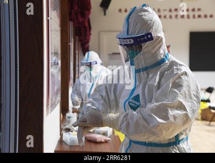 210122 -- PECHINO, 22 gennaio 2021 -- Un operatore medico disinfetta le mani prima di raccogliere campioni in un sito di test nel distretto di Xicheng, Pechino, capitale della Cina, 22 gennaio 2021. Pechino ha riferito tre nuovi casi confermati di COVID-19 trasmessi localmente, una nuova infezione asintomatica trasmessa localmente e due nuovi casi asintomatici importati giovedì, la commissione sanitaria municipale ha detto venerdì. Tutte le persone che vivono o lavorano nei distretti di Dongcheng e Xicheng saranno sottoposte a test sugli acidi nucleici per la COVID-19 venerdì e sabato, secondo i distretti prevenzione COVID-19 e c Foto Stock