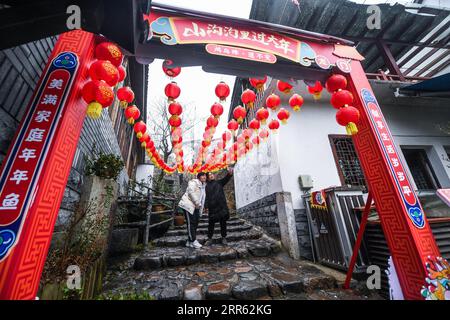 210123 -- HANGZHOU, 23 gennaio 2021 -- i visitatori posano per le foto nell'antico villaggio di Maotang nel distretto di Yuhang di Hangzhou, capitale della provincia dello Zhejiang della Cina orientale, 22 gennaio 2021. Situato nell'area montuosa occidentale di Hangzhou, l'antico villaggio di Maotang ha una lunga storia e molti antichi edifici di Huizhou. Con l'avvicinarsi del Festival di Primavera, qui si svolgono attività popolari come il mercato primaverile, la scrittura di coupon, la preparazione di torte di riso appiccicoso e il taglio della carta, per consentire ai visitatori di sperimentare le tradizioni tradizionali cinesi. CHINA-ZHEJIANG-MAOTANG ANTICO VILLAGGIO-CAPODANNO-TRADIZIONI POPOLARI CN XUXYU PUB Foto Stock