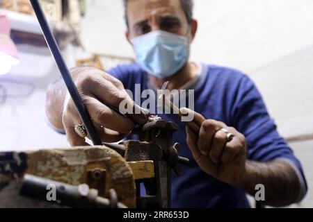 210127 -- BAGHDAD, 27 gennaio 2021 -- un artigiano lavora su un pezzo di gioielleria nel suo laboratorio a Baghdad, Iraq, 26 gennaio 2021. IRAQ-BAGHDAD-GIOIELLERIA Xinhua PUBLICATIONxNOTxINxCHN Foto Stock