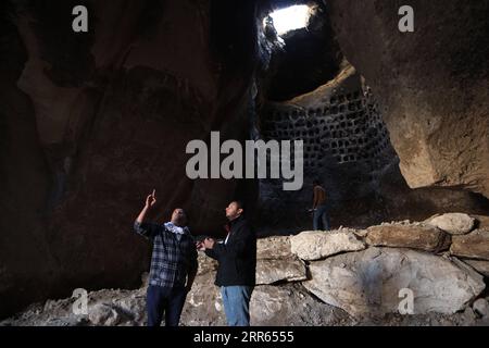 210127 -- HEBRON, 27 gennaio 2021 -- la gente visita la grotta di Tor Beiddou nel villaggio di Idhna, a ovest della città di Hebron, 24 gennaio 2021. La grotta di 300 metri quadrati comprende scantinati profondi e fori di piccione scavati nelle pareti rocciose della grotta, mentre i raggi di luce solare cadono da un foro circolare nel soffitto della grotta. DA NON PERDERE: L'antica grotta diventa attrazione turistica in Palestina S Hebron foto di /Xinhua MIDEAST-HEBRON-ANCIENT CAVE MamounxWazwaz PUBLICATIONxNOTxINxCHN Foto Stock