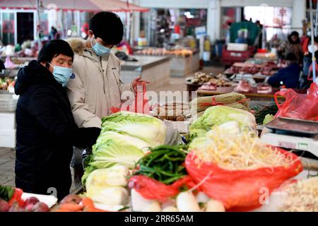 210127 -- HEFEI, 27 gennaio 2021 -- Cheng Baoliu negozi di verdure con sua madre in un mercato a Hefei, provincia di Anhui, Cina orientale, 24 gennaio 2021. Cheng Baoliu imparò a prendersi cura della sua madre ipovedente e a fare faccende domestiche in giovane età, dal momento che suo padre era lontano da casa per lavoro e Cheng era l'unico su cui sua madre poteva contare. Nel corso degli anni, con l'aiuto della società, la loro vita sta migliorando. Cheng è ora un secondo studente in un'università di Hefei, e anche suo padre ha trovato un lavoro nella loro città natale. Cheng fa ancora del suo meglio per aiutare, facendo part-time Foto Stock