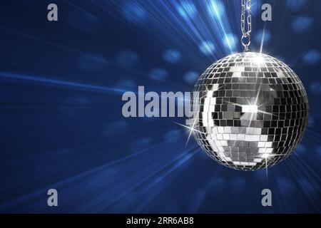 Disco ball brillante e brillante su sfondo blu, spazio per il testo Foto Stock
