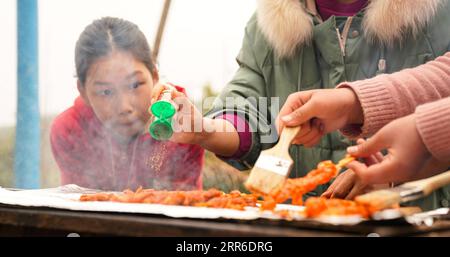 210208 -- NANCHANG, 8 febbraio 2021 -- lo studente li Yuchun guarda la produzione di barbecue nel villaggio di Miaojiling di Zhuting Township nella città di Yichun, provincia di Jiangxi, Cina orientale, 3 febbraio 2021. Wang Pian, 25 anni, è un insegnante della Zhuting Central Elementary School nella Zhuting Township della città di Yichun. Con l'avvicinarsi del Festival di Primavera, Wang non è in grado di incontrare i suoi genitori per le festività di quest'anno, quando le persone di tutto il paese tornano tradizionalmente a casa per l'unione familiare, perché i suoi genitori lavorano in altri luoghi della Cina e hanno scelto di rimanere in vacanza per ridurre il rischio di infezione da COVID-19 Foto Stock