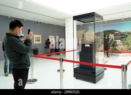 210212 -- PECHINO, 12 febbraio 2021 -- Un visitatore scatta foto di una testa di Buddha in pietra di una statua nella Grotta 8 delle Grotte di Tianlongshan durante una mostra al Museo Luxun di Pechino, capitale della Cina, 12 febbraio 2021. Una testa di Buddha in pietra che è stata rubata dalla Cina quasi un secolo fa e recuperata di recente è apparsa in una mostra al Museo di Pechino Luxun a partire da venerdì, che è il Capodanno lunare cinese. La testa del Buddha appartiene a una delle molte statue di pietra nella parte settentrionale delle Grotte di Tianlongshan della Cina, nella città di Taiyuan nella provincia dello Shanxi. Era la 100a reliquia recuperata dalla Cina Foto Stock