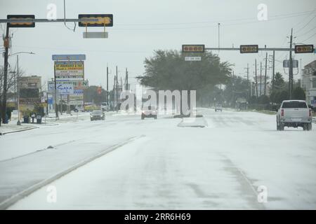 210216 -- PECHINO, 16 febbraio 2021 -- i veicoli si spostano su una strada innevata a Houston, Texas, Stati Uniti, il 15 febbraio 2021. Fino a 2,5 milioni di clienti erano privi di energia nello stato americano del Texas lunedì mattina, poiché la capacità di generazione di energia dello stato è influenzata da una tempesta invernale in corso causata dall'esplosione dell'Artico. Foto di /Xinhua XINHUA FOTO DEL GIORNO ChengyuexLao PUBLICATIONxNOTxINxCHN Foto Stock