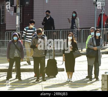 210218 -- HONG KONG, 18 febbraio 2021 -- le persone che indossano maschere per il viso camminano in una strada a Hong Kong, nel sud della Cina, 18 febbraio 2021. Il Centro per la protezione della salute di Hong Kong CHP ha riportato otto nuove infezioni di COVID-19 giovedì, portando il totale a 10.820. CHINA-HONG KONG-COVID-19-CASESCN LoxPingxFai PUBLICATIONxNOTxINxCHN Foto Stock