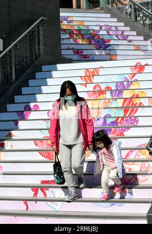 210218 -- HONG KONG, 18 febbraio 2021 -- le persone che indossano maschere per il viso camminano in una strada a Hong Kong, nel sud della Cina, 18 febbraio 2021. Il Centro per la protezione della salute di Hong Kong CHP ha riportato otto nuove infezioni di COVID-19 giovedì, portando il totale a 10.820. CHINA-HONG KONG-COVID-19-CASESCN LoxPingxFai PUBLICATIONxNOTxINxCHN Foto Stock