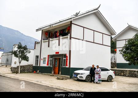 210222 -- QIANXI, 22 febbraio 2021 -- Yang Jun del gruppo eterotico Miao e sua moglie Yang Hongxian posano per una foto accanto alla loro nuova casa e nuova auto nel sito di trasferimento per le persone colpite dalla povertà nel villaggio di Huawu, nella contea di Qianxi della città di Bijie, nella provincia di Guizhou nella Cina sud-occidentale, 20 febbraio 2021. Situato nella profonda area montuosa di Xinren Miao Township di Guizhou, il villaggio di Huawu è famoso per i suoi incredibili paesaggi. Negli ultimi anni, con gli sforzi del governo locale, il villaggio sviluppa la piantagione, la coltivazione e il turismo, trasferendo al contempo le persone colpite dalla povertà. Oggigiorno Huawu ha preso il sopravvento Foto Stock