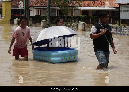 210222 -- GIAVA OCCIDENTALE, 22 febbraio 2021 -- la gente cammina attraverso le acque alluvionali a causa dell'alta intensità delle precipitazioni e del traboccamento del fiume Citarum a Bekasi, Giava Occidentale, Indonesia, 22 febbraio 2021. Foto di /Xinhua INDONESIA-WEST JAVA-FLOOD AryaxManggala PUBLICATIONxNOTxINxCHN Foto Stock