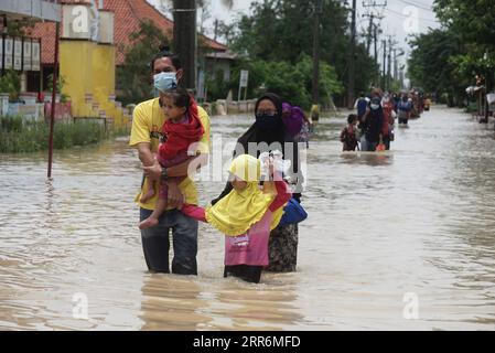 210222 -- GIAVA OCCIDENTALE, 22 febbraio 2021 -- la gente cammina attraverso le acque alluvionali a causa dell'alta intensità delle precipitazioni e del traboccamento del fiume Citarum a Bekasi, Giava Occidentale, Indonesia, 22 febbraio 2021. Foto di /Xinhua INDONESIA-WEST JAVA-FLOOD AryaxManggala PUBLICATIONxNOTxINxCHN Foto Stock