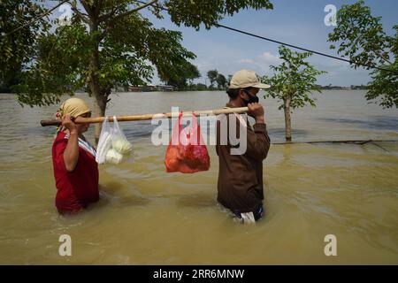 210222 -- GIAVA OCCIDENTALE, 22 febbraio 2021 -- la gente cammina attraverso le acque alluvionali a causa dell'alta intensità delle precipitazioni e del traboccamento del fiume Citarum a Bekasi, Giava Occidentale, Indonesia, 22 febbraio 2021. Foto di /Xinhua INDONESIA-WEST JAVA-FLOOD JefrixTarigan PUBLICATIONxNOTxINxCHN Foto Stock