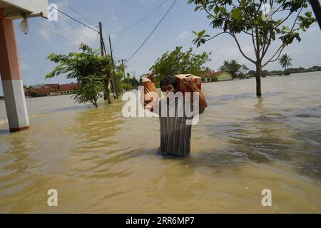 210222 -- GIAVA OCCIDENTALE, 22 febbraio 2021 -- Un uomo cammina attraverso le acque alluvionali a causa dell'alta intensità delle precipitazioni e del traboccamento del fiume Citarum a Bekasi, Giava Occidentale, Indonesia, 22 febbraio 2021. Foto di /Xinhua INDONESIA-WEST JAVA-FLOOD JefrixTarigan PUBLICATIONxNOTxINxCHN Foto Stock