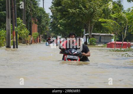 210222 -- GIAVA OCCIDENTALE, 22 febbraio 2021 -- la gente spinge una moto attraverso le acque alluvionali a causa dell'alta intensità delle precipitazioni e del traboccamento del fiume Citarum a Bekasi, Giava Occidentale, Indonesia, 22 febbraio 2021. Foto di /Xinhua INDONESIA-WEST JAVA-FLOOD JefrixTarigan PUBLICATIONxNOTxINxCHN Foto Stock