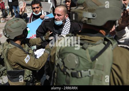 210226 -- HEBRON, 26 febbraio 2021 -- soldati israeliani si scontrano con manifestanti palestinesi durante una protesta che segna il 27° anniversario del massacro della moschea di Ibrahimi nella città di Hebron, 26 febbraio 2021. Il 25 febbraio 1994, Baruch Goldstein, un colono e medico di riserva delle forze di difesa israeliane, entrò nella moschea durante le preghiere dell'alba in una mattina del Ramadan e uccise 29 adoratori. Foto di /Xinhua MIDEAST-HEBRON-PROTESTA MamounxWazwaz PUBLICATIONxNOTxINxCHN Foto Stock