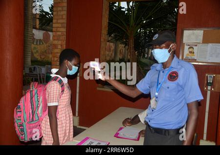 210301 -- KAMPALA, 1 marzo 2021 -- Una guardia di sicurezza prende la temperatura di un allievo a Kampala, Uganda, 1 marzo 2021. Gli studenti ugandesi in classi semi-candidate di primaria 6, terza e quinta hanno ripreso gli studi lunedì. Foto di /Xinhua UGANDA-KAMPALA-COVID-19-SCHOOL-REOPEN NicholasxKajoba PUBLICATIONxNOTxINxCHN Foto Stock