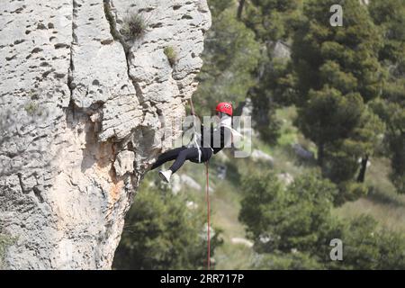 210307 -- HEBRON, 7 marzo 2021 -- Una donna palestinese si arrampica su una scogliera ripida nella riserva naturale di Wadi al-Qaf nella città di Hebron in Cisgiordania, 5 marzo 2021. Contrariamente a quanto è comune nella loro società, un gruppo di giovani donne palestinesi partecipa alla discesa in corda doppia dalle pericolose scogliere della Cisgiordania. Foto di /Xinhua TO GO WITH Feature: Giovani donne palestinesi rinfrescate in rappelling in Cisgiordania MIDEAST-HEBRON-PALESTINIAN WOMEN-RAPPELLING MamounxWazwaz PUBLICATIONxNOTxINxCHN Foto Stock