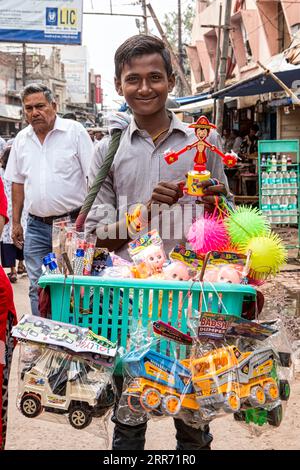 Vrindavan, Uttar Pradesh, 18 ottobre 2019: Un giovane ragazzo che vende giocattoli su una strada trafficata di Vrindavan, la città Santa per gli indù Foto Stock